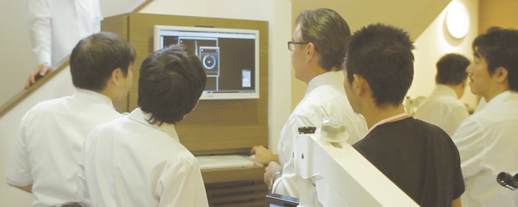 A photo of a student looking at an image in front of an X-ray machine